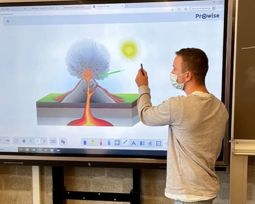 Die Lehrkraft zeigt einen Vulkan auf dem Prowise Presenter.